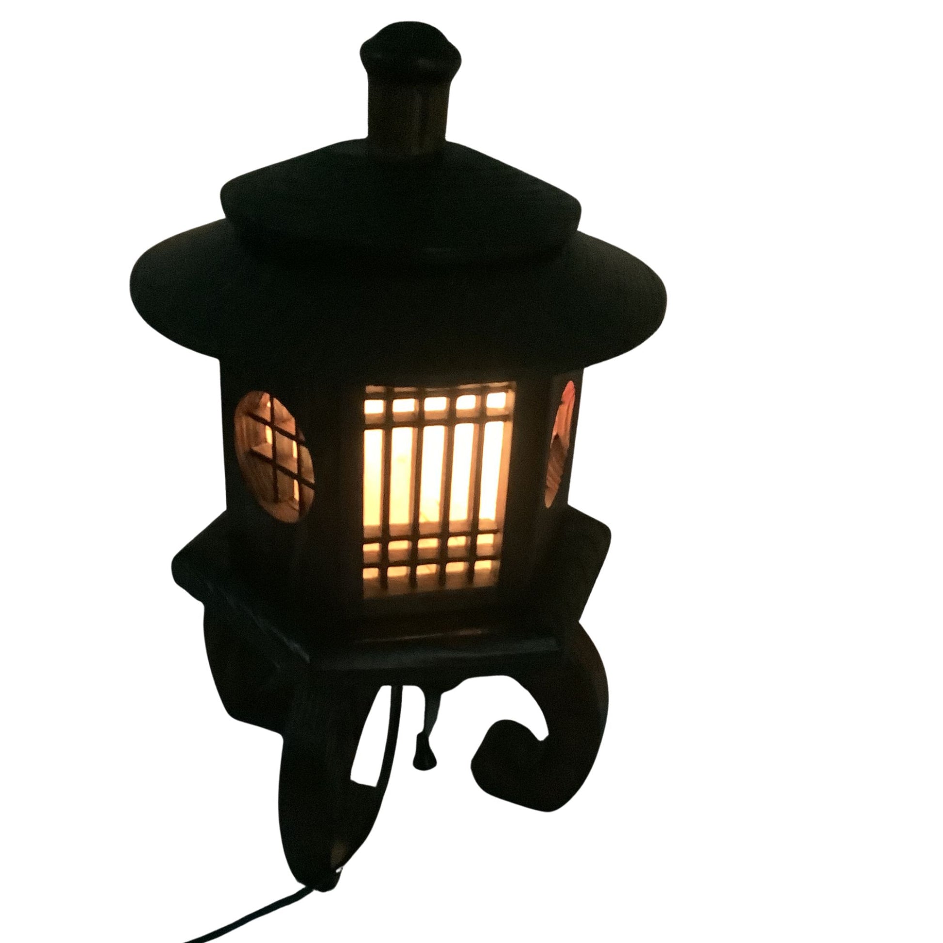 A brown decorative Japanese lamp with a warm yellow light glowing through its slatted front and side panels, shown against a plain white background.