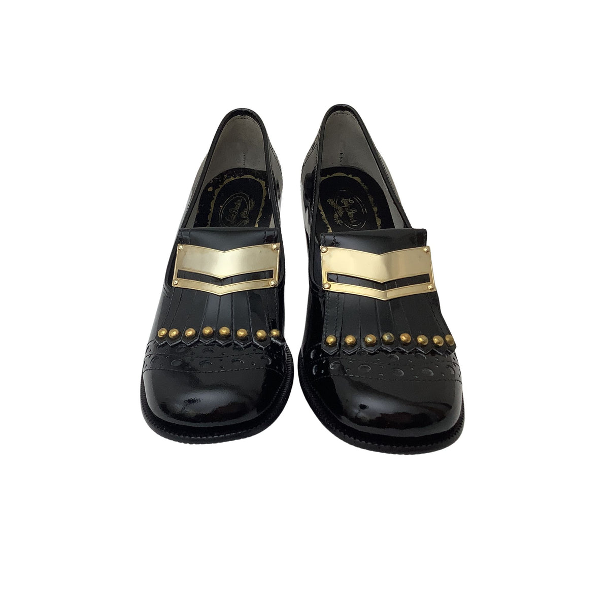 A pair of vintage black leather loafers with gold chevron metal accents, gold studs, and brogue detailing, shown from a top-down view on a white background.