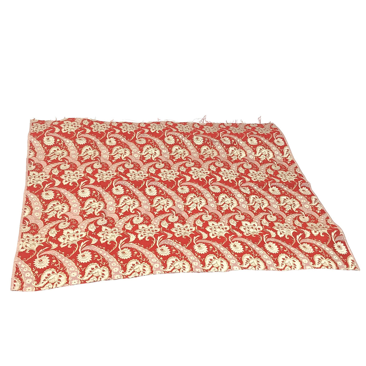 A rectangular piece of red and gold vintage fabric with an intricate stylized floral pattern, laid flat against a white background.