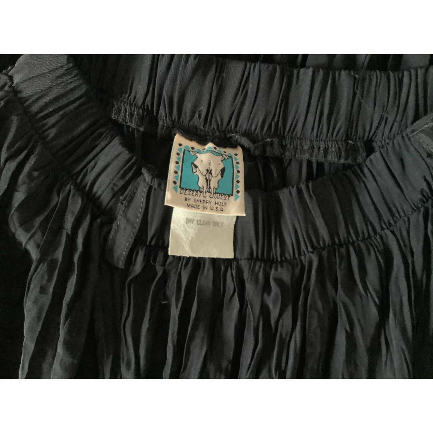 Close-up of a black pleated Sherry Holt Skirt sewn-in care label view