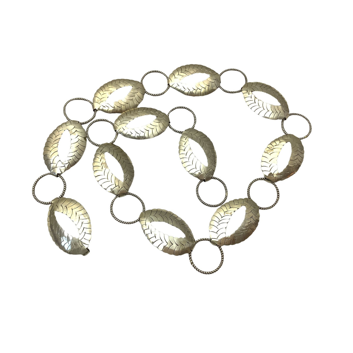 A vintage-style metallic link chain belt featuring elongated oval links with leaf-like textured patterns and circular connector rings, shown on a plain white background.