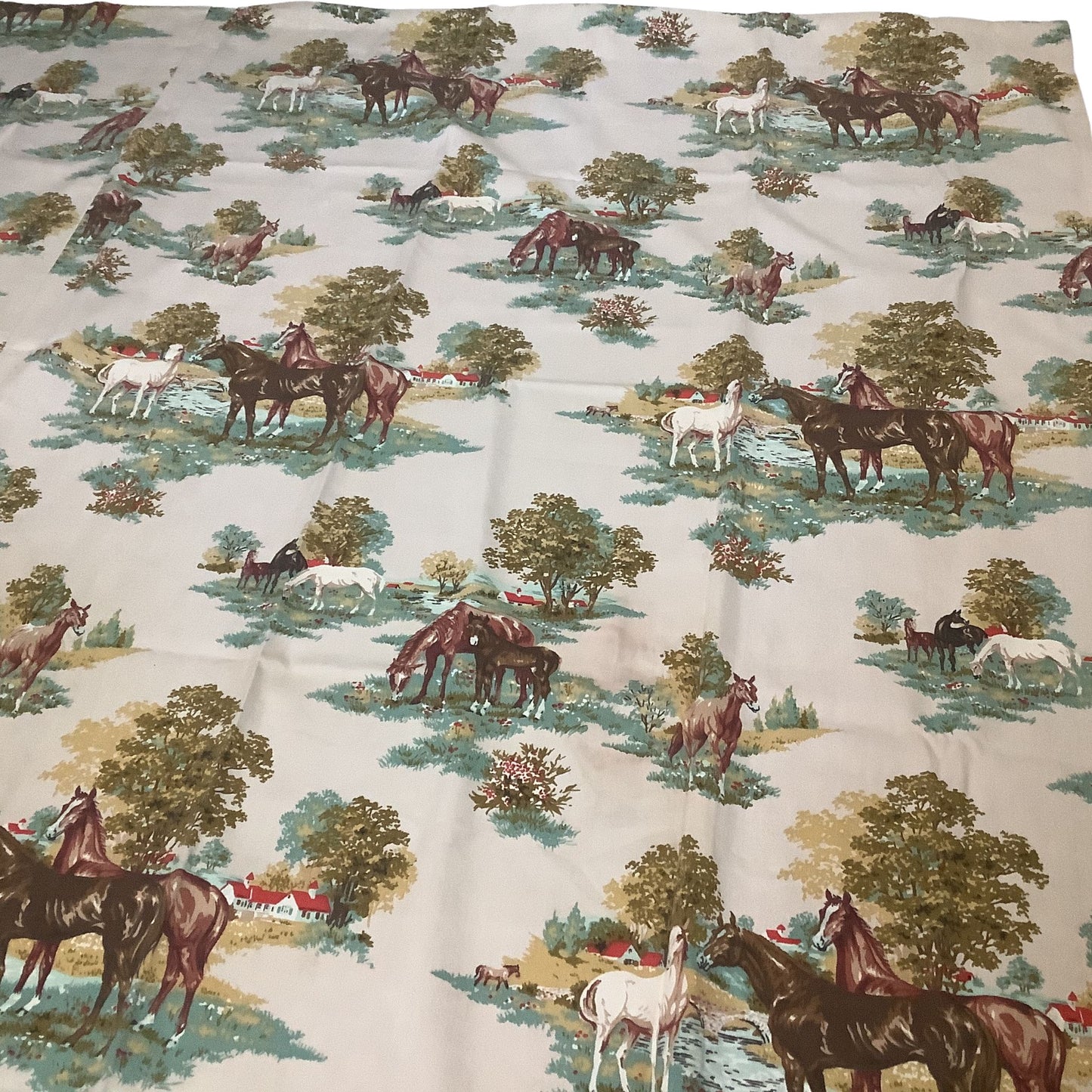 A close-up of a vintage western curtain featuring a classic toile-style print of horses, trees, and barns.