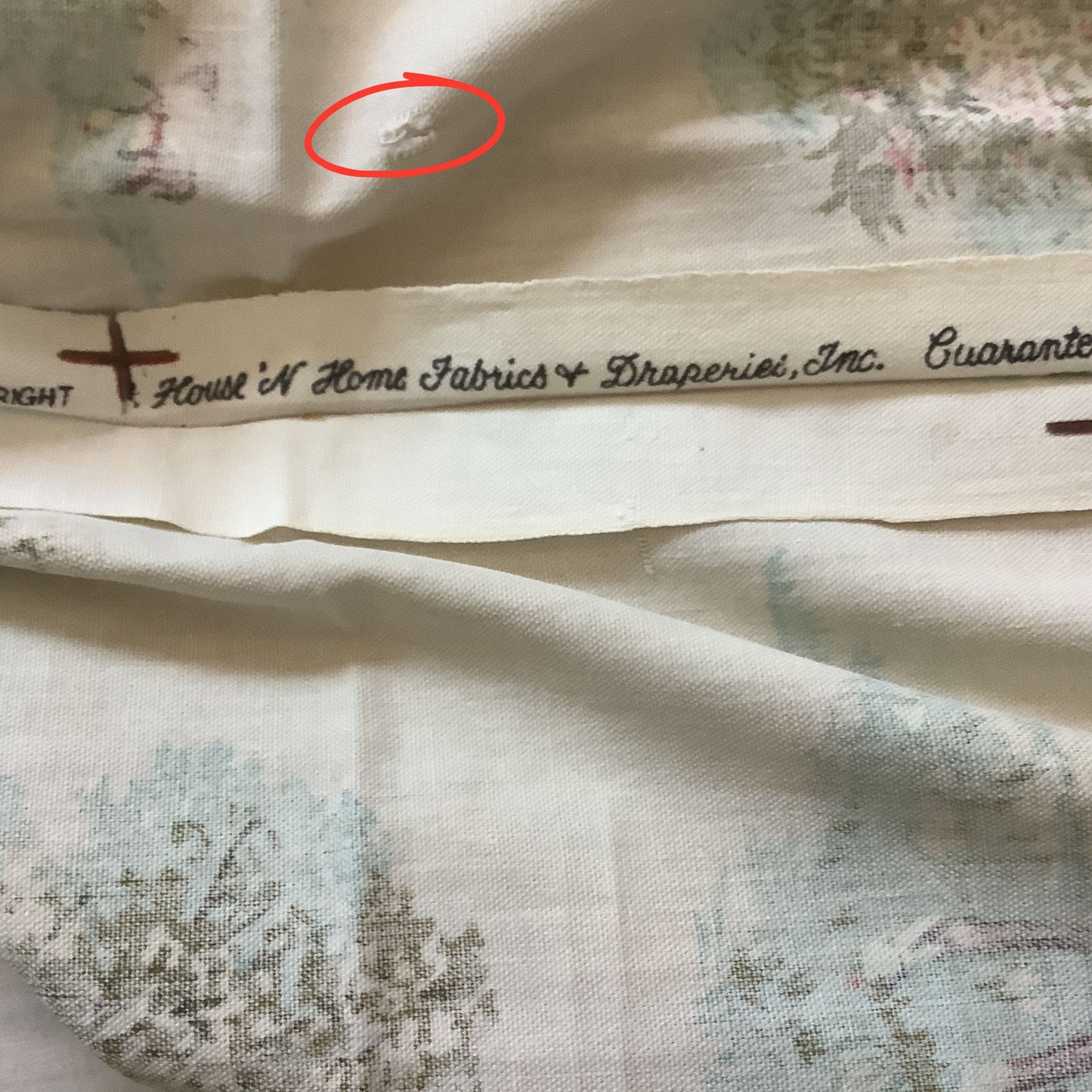 Vintage curtain panel showing brand House'n Home Fabrics with circled in red small hole.