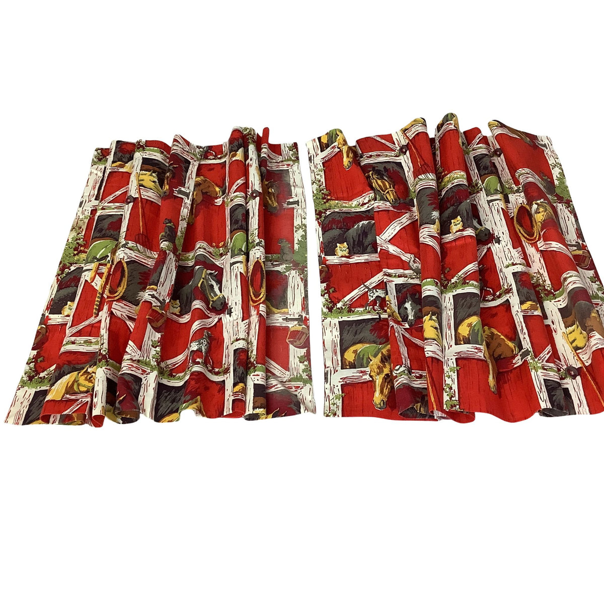 A pair of short red curtains with a vintage-style printed pattern featuring soldiers, horses, and buildings, displayed against a solid white background.