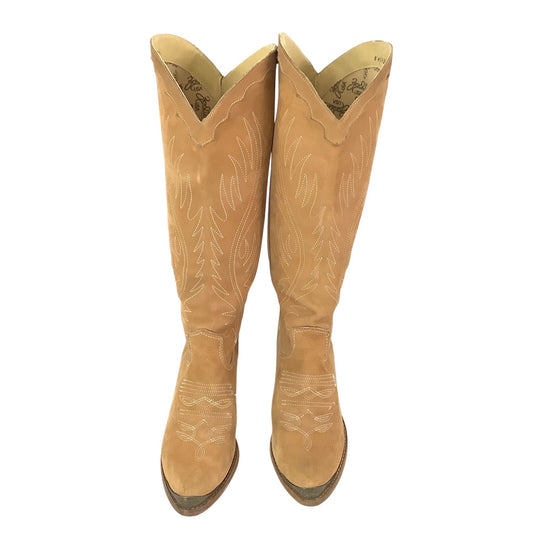 A pair of tall Zodiac brown/tan suede cowboy boots with white embroidered floral and geometric patterns, shown from a top-down view on a white background.