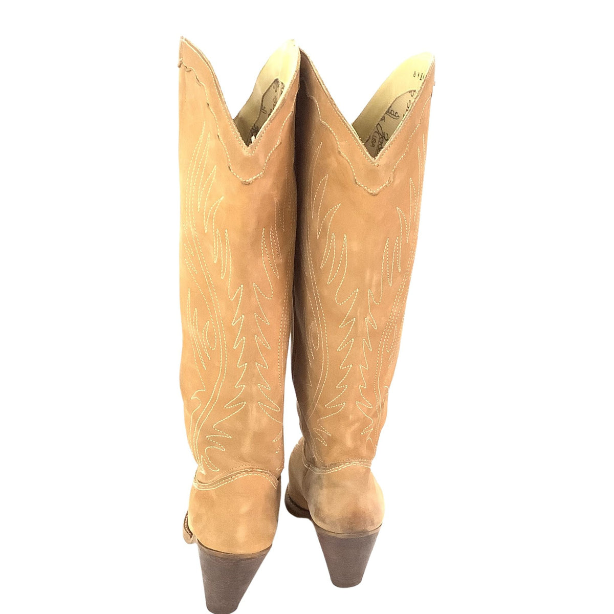 A pair of tall tan suede cowboy boots with white embroidered details, shown from the back against a white background.