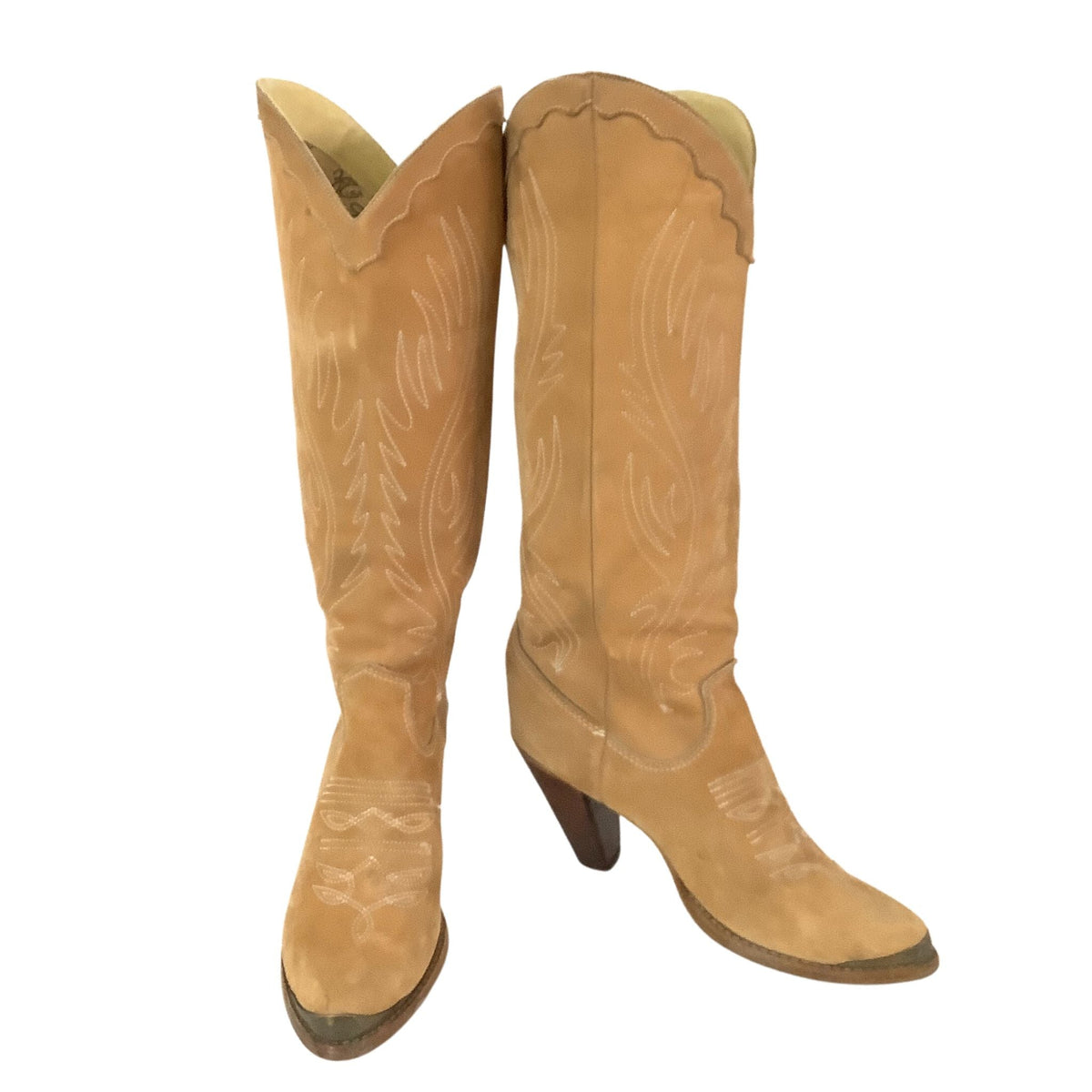 A pair of tan suede cowboy boots with white western embroidery, shown against a plain white background.