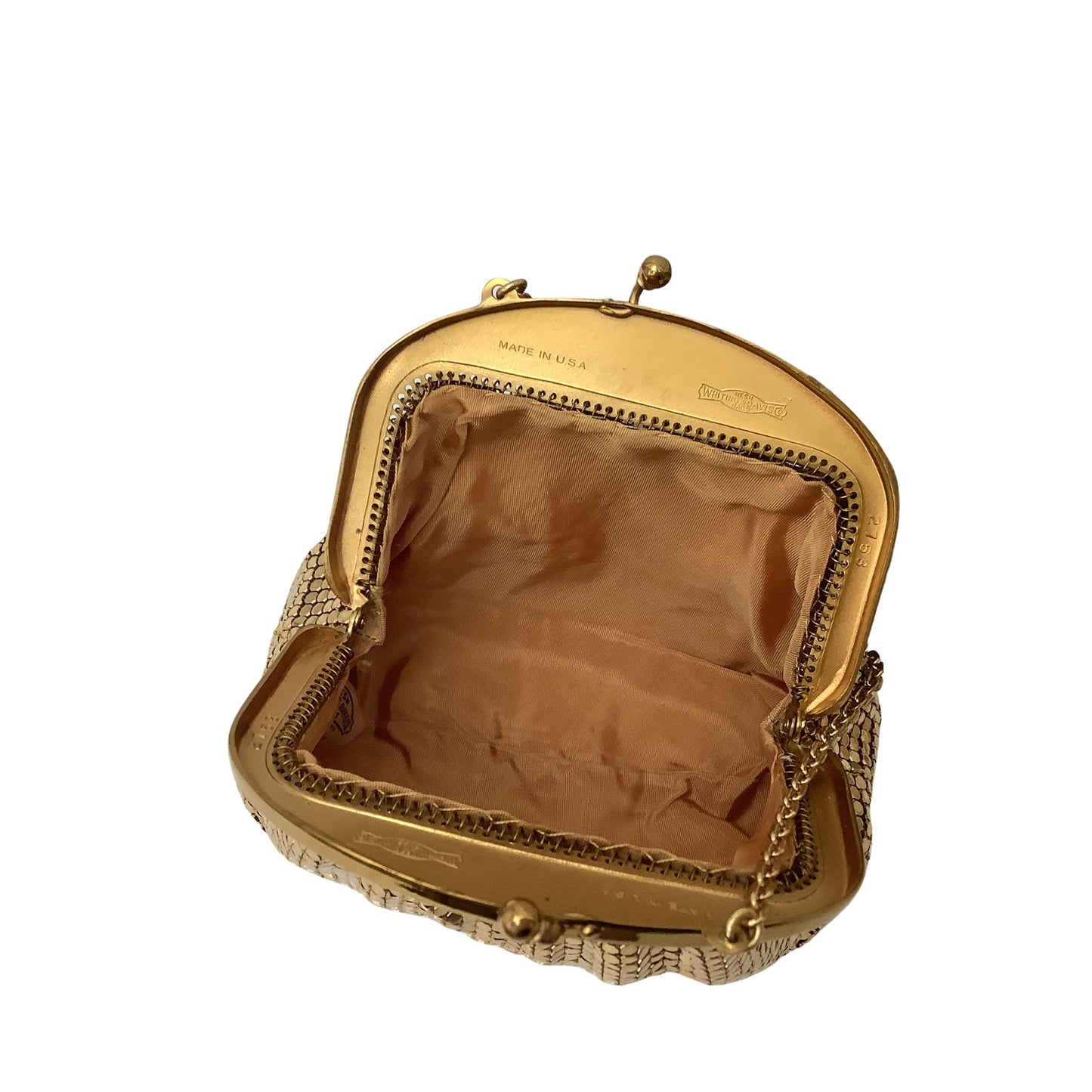 An open vintage Whiting & Davis metallic clutch purse with a gold-tone frame, patterned exterior, and tan rayon lining, shown on a plain white background.